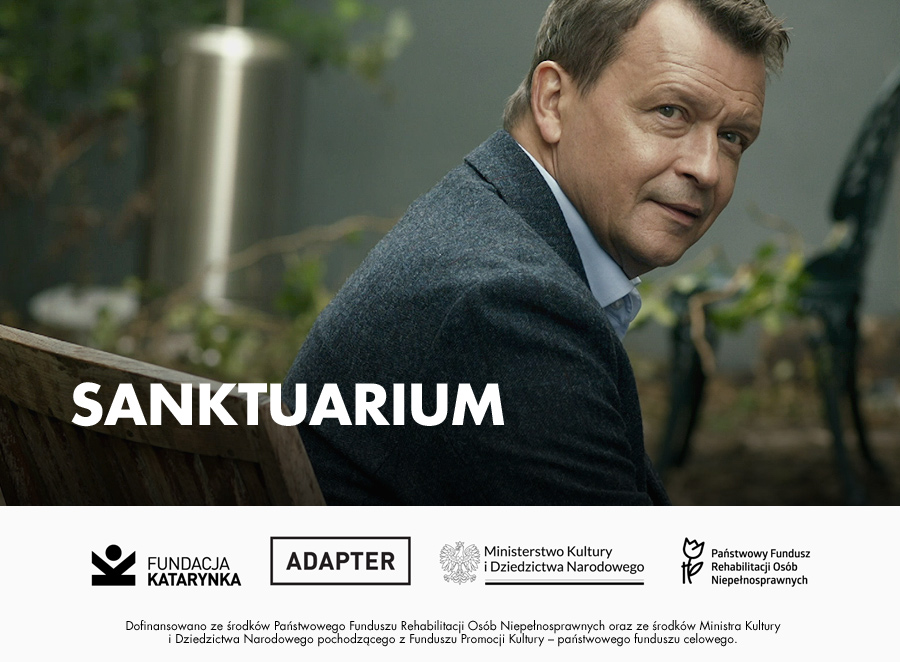 Kolorowe zdjęcie Jana Frycza. Poniżej logotypy: Fundacja Katarynka, Adapter, Ministerstwo Kultury i Dziedzictwa Narodowego, Państwowy Fundusz Rehabilitacji Osób Niepełnosprawnych. Poniżej napis Dofinansowana ze środków Państwowego Funduszu Rehabilitacji Osób Niepełnosprawnych oraz ze środków Ministra Kultury i Dziedzictwa Narodowego pochodzącego z Funduszu Promocji Kultury - państwowego funduszu celowego.