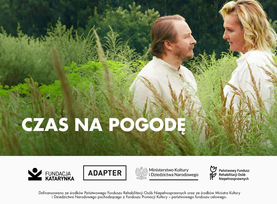 Kolorowy kadr z filmu. Dwoje głównych bohaterów ubranych na biało stoi w gąszczu wysokich traw. Stoją naprzeciwko siebie i wymieniają głębokie spojrzenia. W tle bujny, ciemnozielony las. Poniżej biały pasek, na nim logotypy: Fundacja Katarynka, Adapter, Ministerstwo Kultury i Dziedzictwa Narodowego, Państwowy Fundusz Rehabilitacji Osób Niepełnosprawnych. Poniżej zdanie: Dofinansowano ze środków Państwowego Funduszu Rehabilitacji Osób Niepełnosprawnych oraz ze środków Ministra Kultury i Dziedzictwa Narodowego pochodzącego z Funduszu Promocji Kultury - państwowego funduszu celowego.